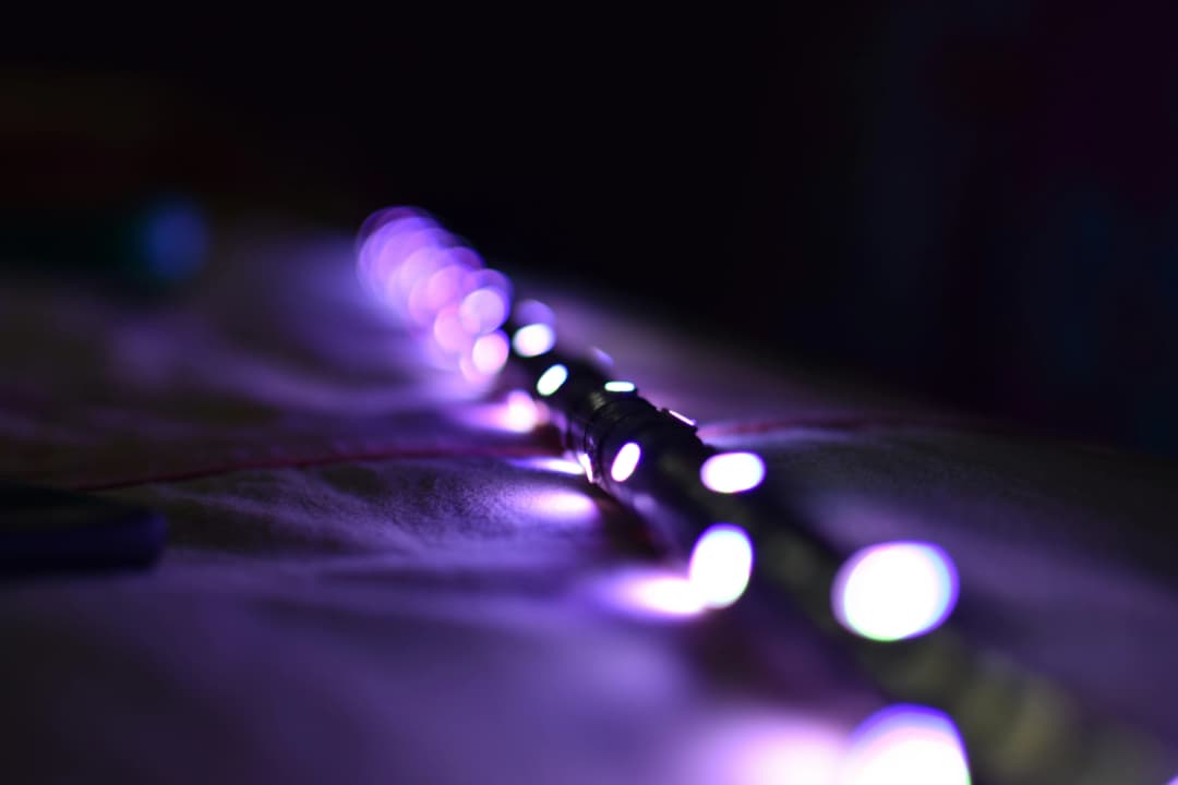 A row of glowing purple LED lights on a dark surface, with a blurred background creating a soft, ambient glow.