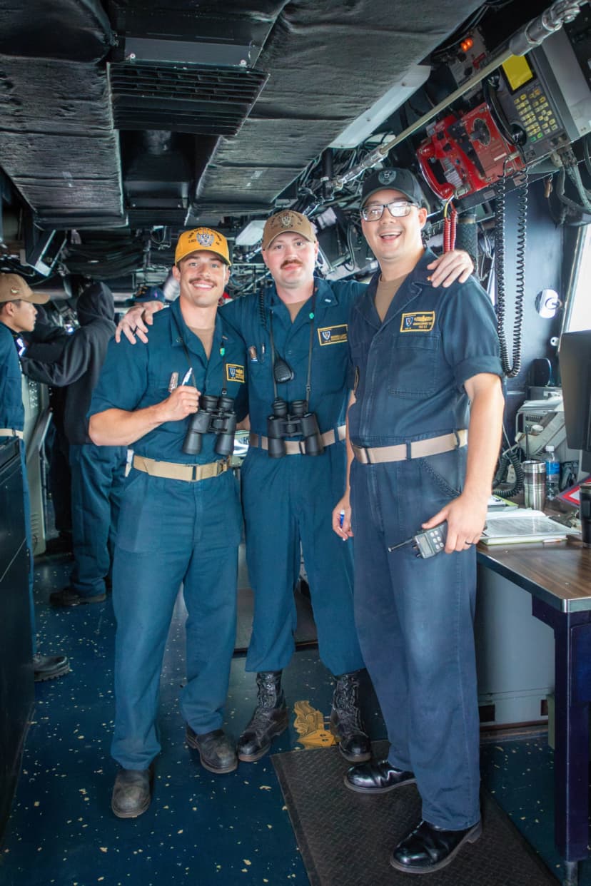 Three crew members in the pilot house