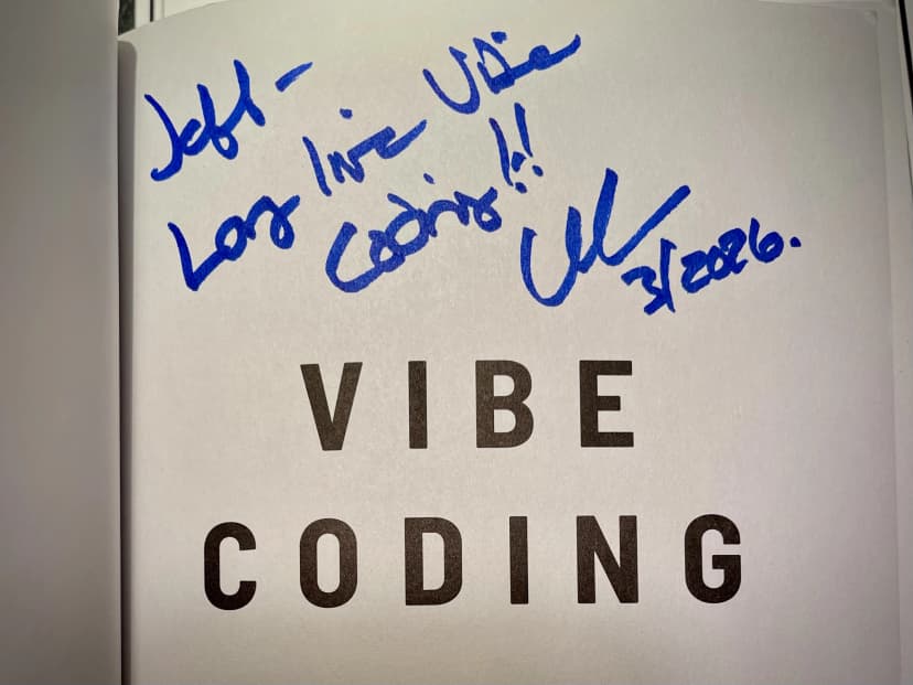Book page signed in blue marker above the words VIBE CODING.